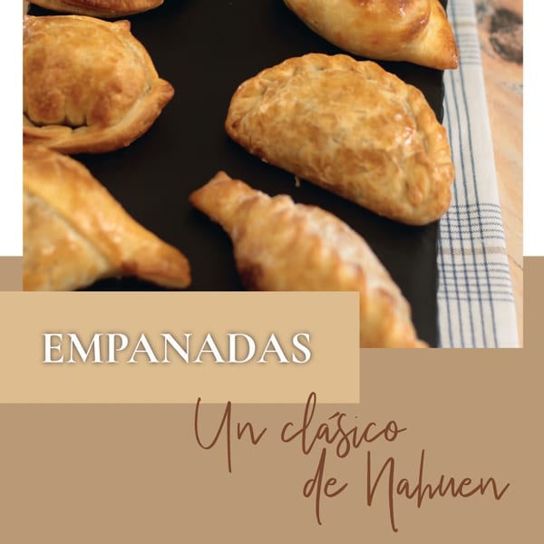 Golden-brown Argentinian empanadas with crimped edges on a dark surface next to a striped napkin.