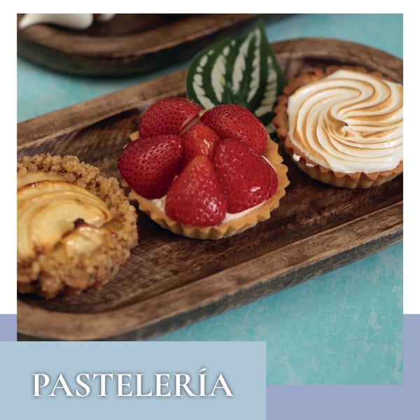 Three Argentinian pastries on a wooden tray: apple crumble, strawberry tart, and meringue tart.