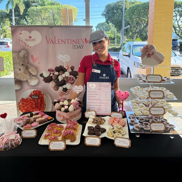 A Nahuen Gourmet Market employee stands by a Valentine's Day display of Argentinian pastries and chocolates.